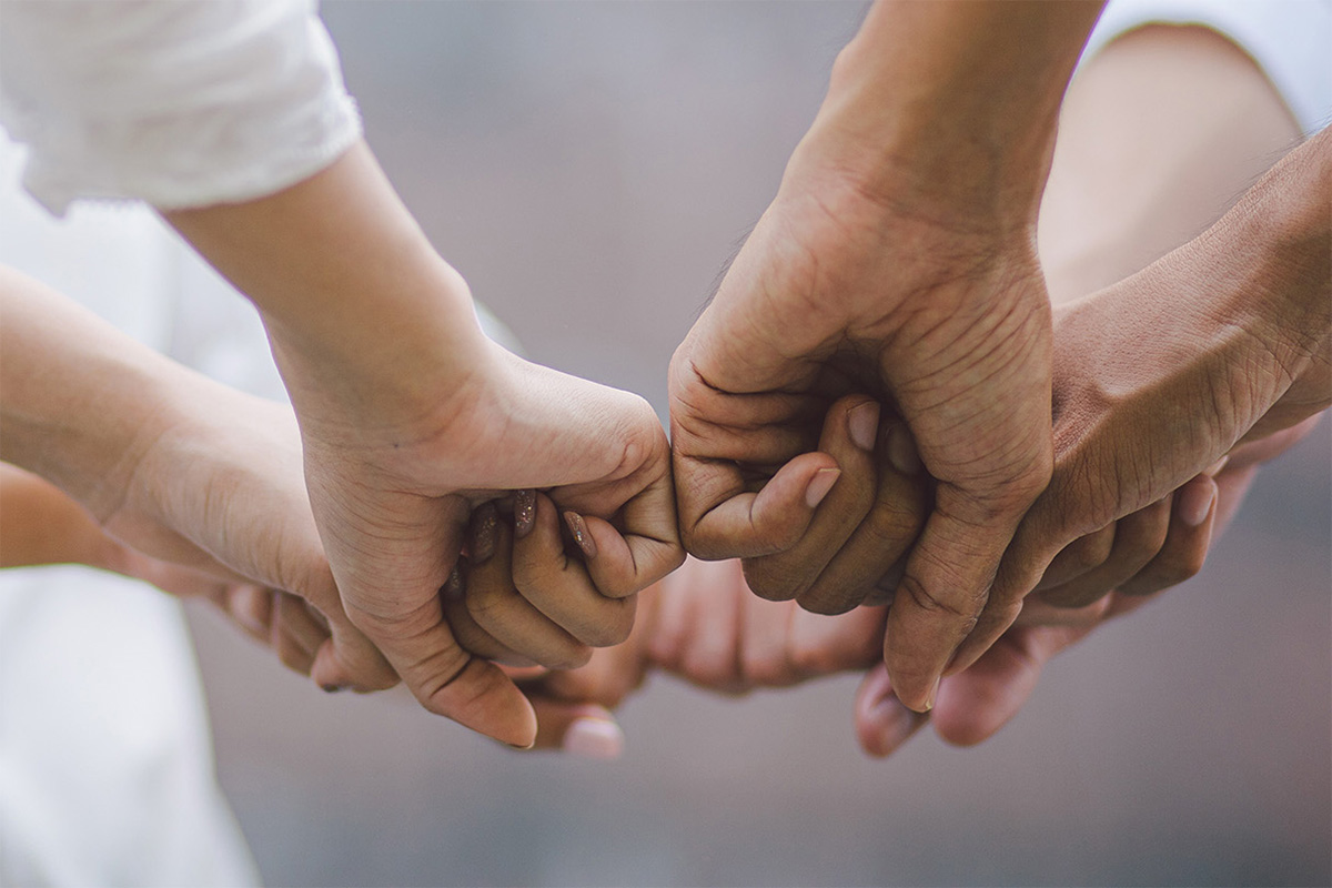 Ein Team legt gemeinsam die F&auml;uste nebeneinander.