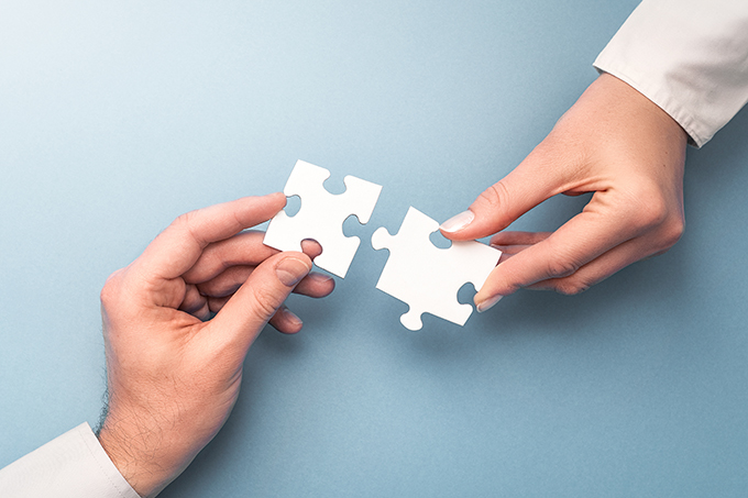 Zwei Personen stecken Puzzleteile zusammen.